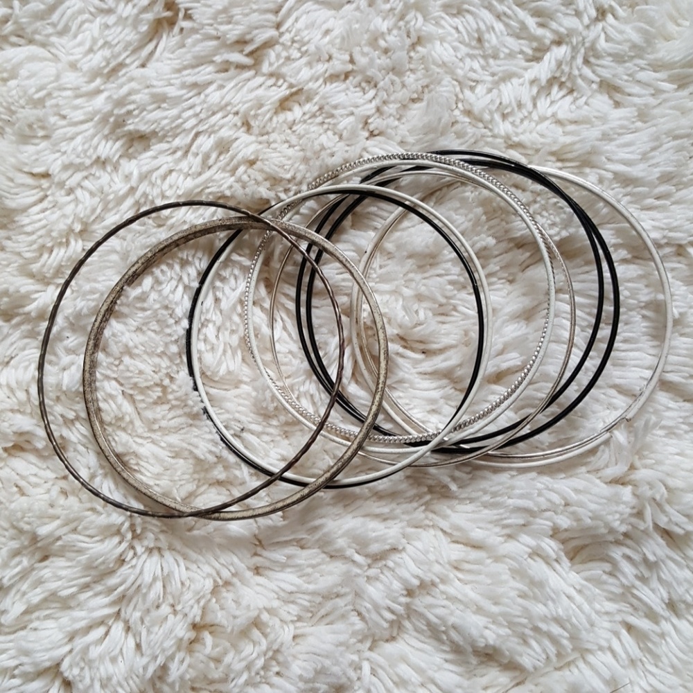 Bundle of silver, white, and black bracelets